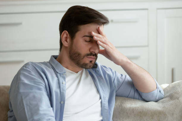 Tired Caucasian man suffer from headache at home