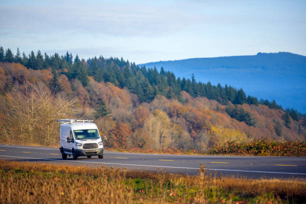 istock Compact commercial mini van running on the spectacular autumn road 1207697307