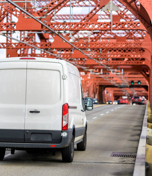 赤いトラス橋を運転する白い商業貨物ミニバン - car delivering white mini van ストックフォトと画像