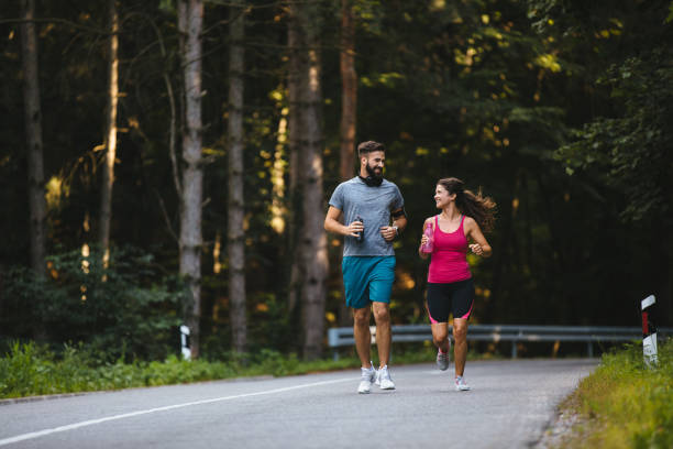 istock Young couple jogging in nature 1207698448