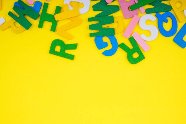 istock ABC wooden letters alphabet scattered on a yellow background. 1207698849