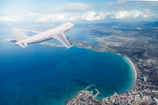 istock airplane flying over a coast city 1207699146