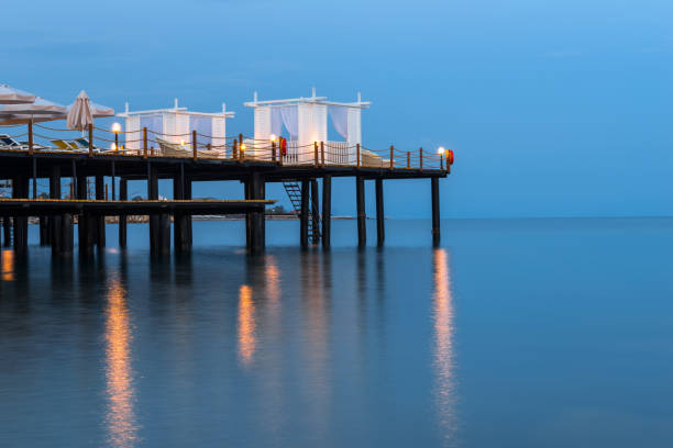 Pier with bungalows and parasols on the beach