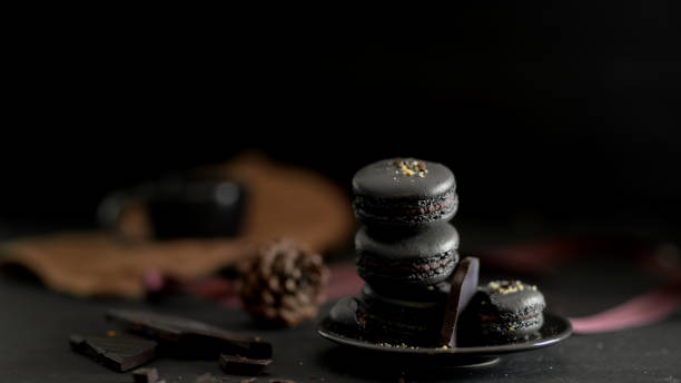 istock Close up view of dark chocolate macarons on black plate on dark table 1207702534