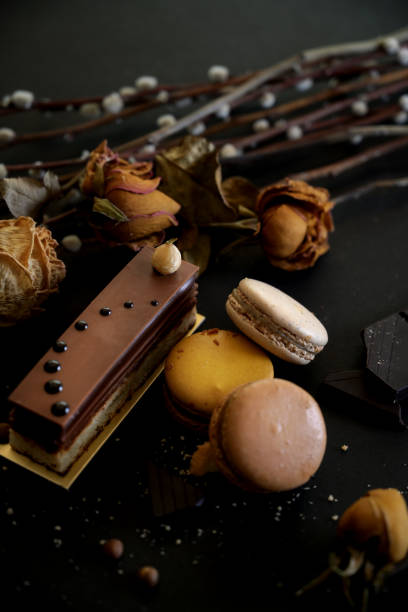istock Cropped shot of chocolate cake and macarons on black table 1207702629