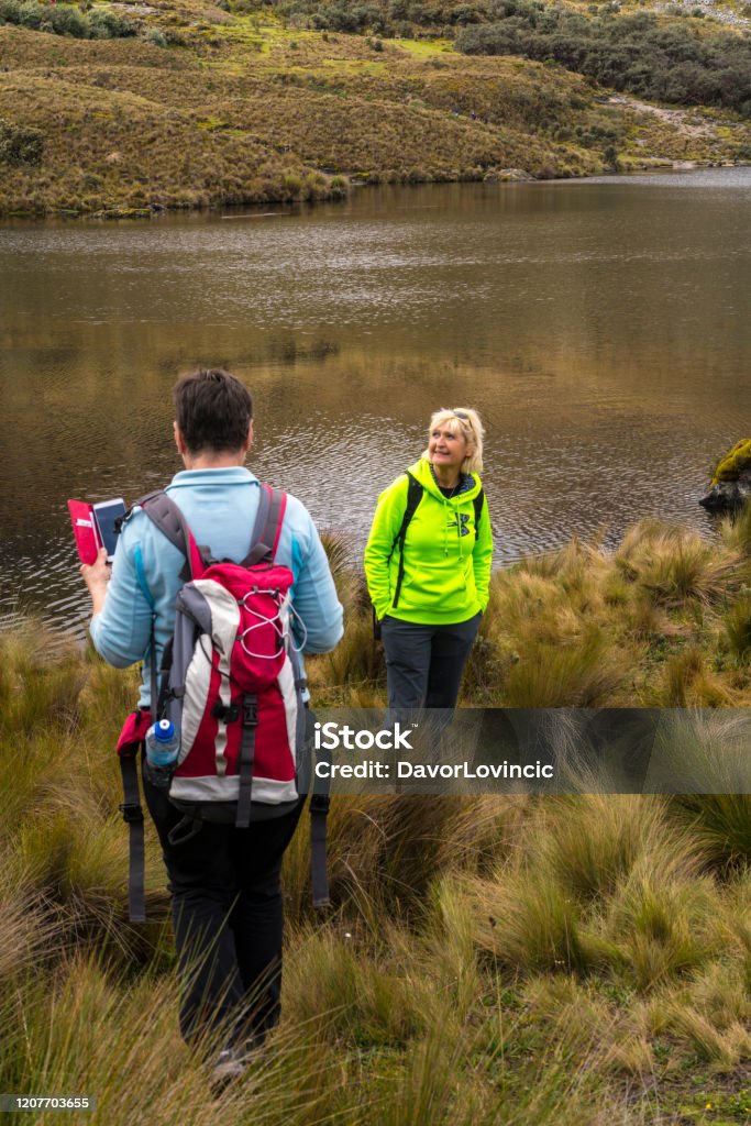 Two beautiful women hiking and enjoying the beauty of nature  at Lake in  El Cajas national park, Ecuador Two beautiful women hiking and enjoying the beauty of nature  at Lake in National park Las Cajas Mountains in Ecuador close to Cuenca city.  There are around 270 lakes on altitude approximately from 3850 m up to 4310 by road, 50-59 Years Stock Photo