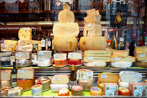 Madrid, Spain - February 14, 2020: Spanish food store with variety of cheese and wine on window display in the center of Madrid.