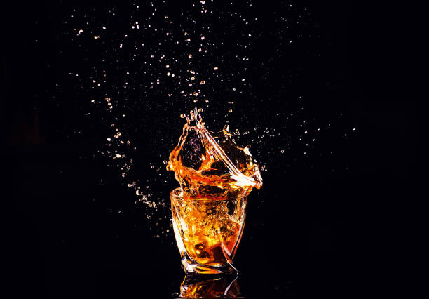 istock Whiskey with splash on black background, brandy in a glass 1207705820