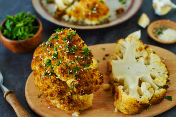 ein ganzer gerösteter blumenkohlkopf mit samen und petersilie - cauliflower roasted parsley cooked stock-fotos und bilder