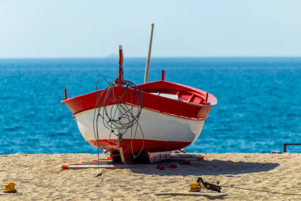 istock Red rowboat on the sand 1207710812