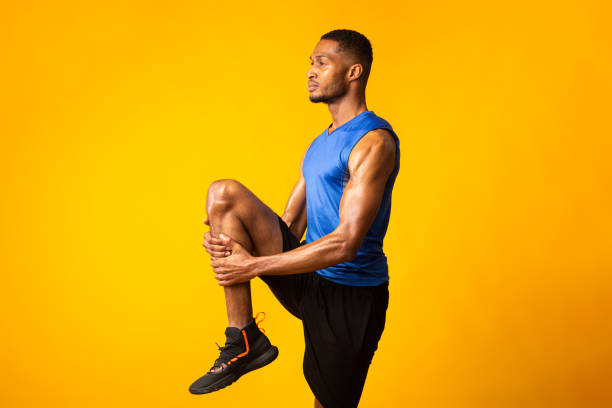 istock Young afro sportsman walks highly holding knee 1207713968