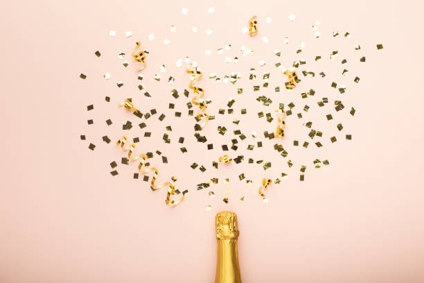 istock Creative flat lay champagne bottle with star confetti on pink 1207714241