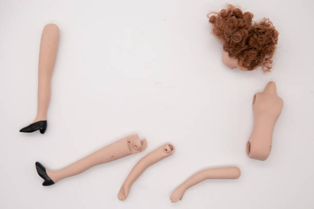 istock Broken Doll Body Parts on white Background 1207715810