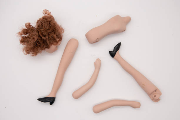 istock Broken Doll Body Parts on white Background 1207715833