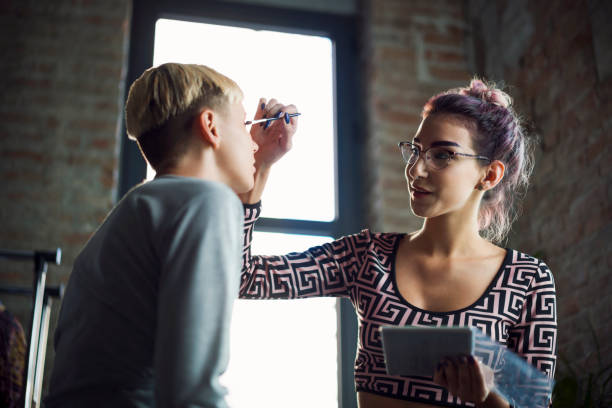 istock Girl putting a makeup on her friend 1207718203