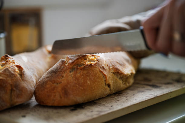 istock Knife cutting into freshly baked bread 1207718341