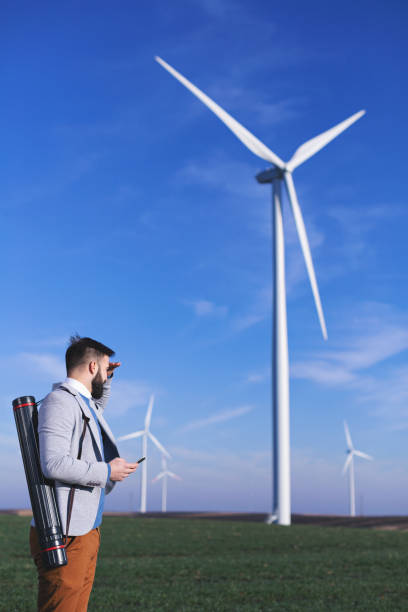istock Young electric engineer outdoors in front of windmills 1207721838