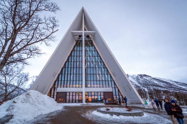 A brilliantly white church by a Fjord near mountains. This Norwegian religious building houses a cemetery for the local hamlet that stay in the quiet Sogndal County.