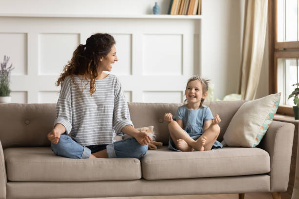 Happy mommy practicing yoga exercised with small child.