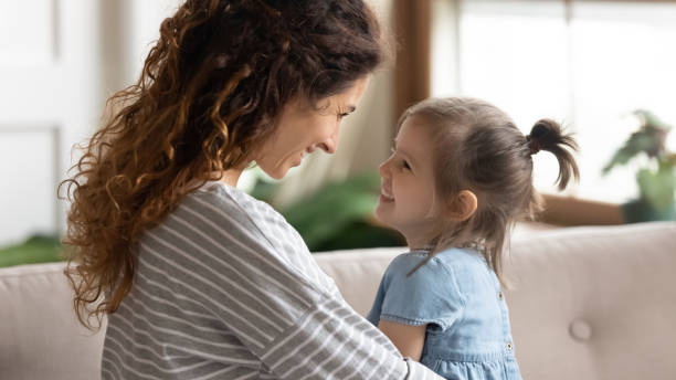 jolie jeune femme regardant le petit gosse adorable de sourire. - multi generation family adoption family human hand photos et images de collection