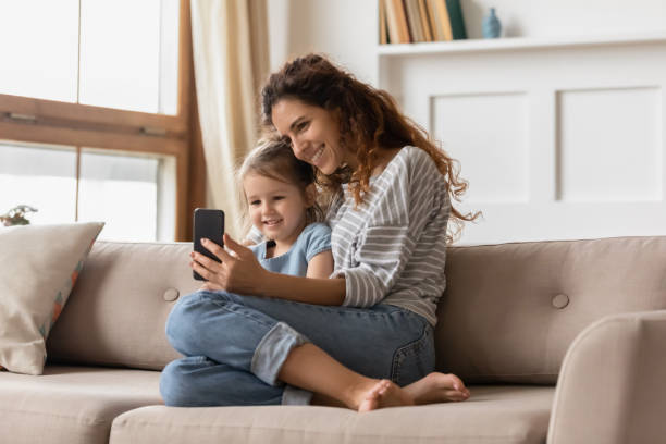 istock Smiling affectionate family of two posing for smartphone selfie. 1207723204