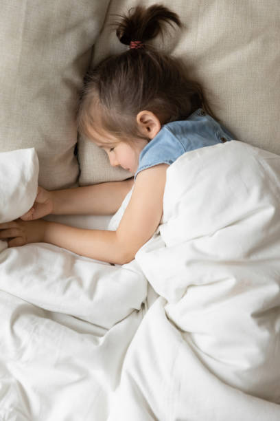 istock Happy peaceful little kid resting alone in cozy bed. 1207723241