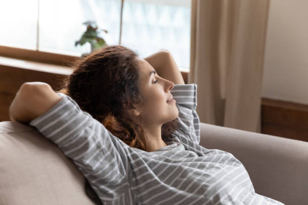 istock Peaceful tranquil attractive young woman taking pause break on couch. 1207723293