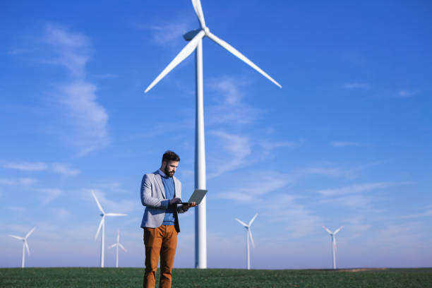 istock Young electric engineer outdoors in front of windmills 1207724590