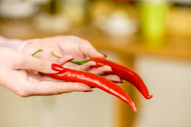 istock Woman holding chilli hot pepper 1207724906