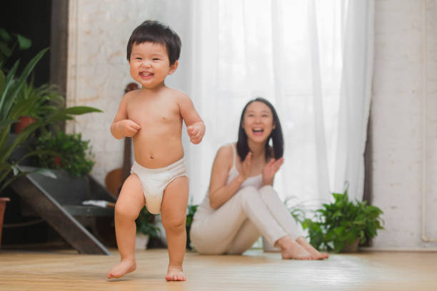 mutter begleitet baby zum spielen - floor sitting stock-fotos und bilder