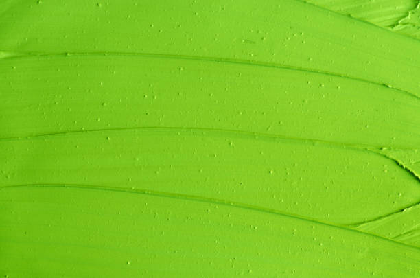 istock Green cosmetic clay (matcha facial mask, green tea and lime face cream, body wrap) texture close up, selective focus. Abstract background with brush strokes 1207727552