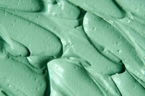 istock Green cosmetic clay (facial mask, face cream, body wrap) texture close up, selective focus. Abstract background with brush strokes. 1207727596