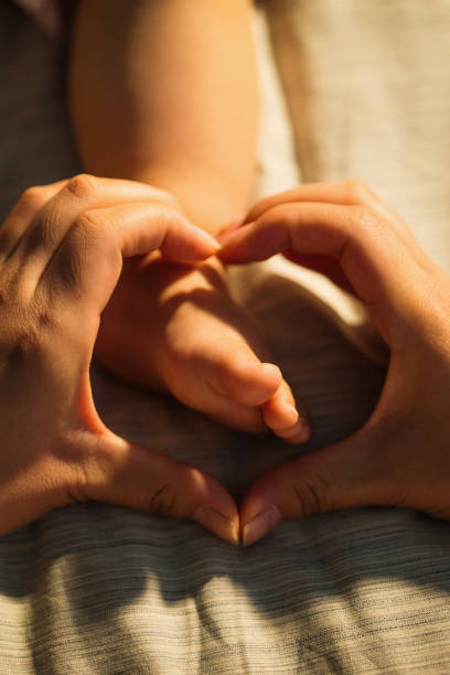 istock Mother holds the baby's feet 1207728141