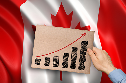 hand showing growing bar graph over canadian flag