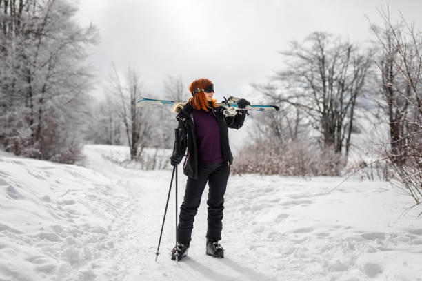 istock Woman carrying ski on mountain 1207729111