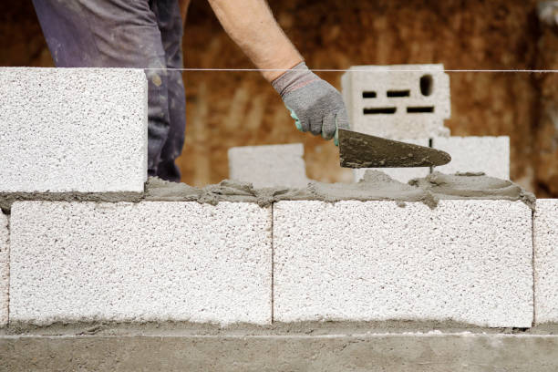Close-up of construction worker builds brick wall