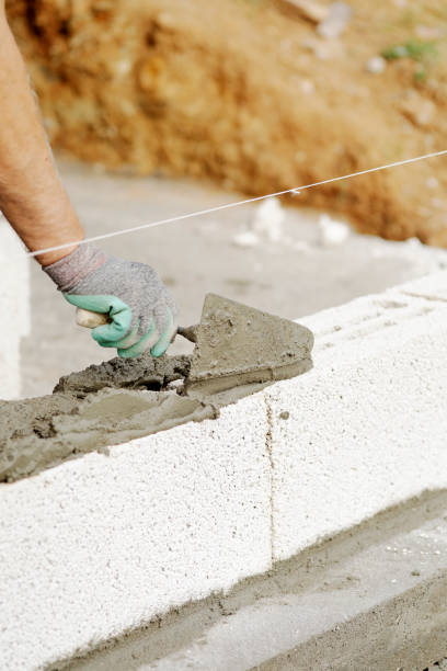 istock Close-up of construction worker builds brick wall 1207732185