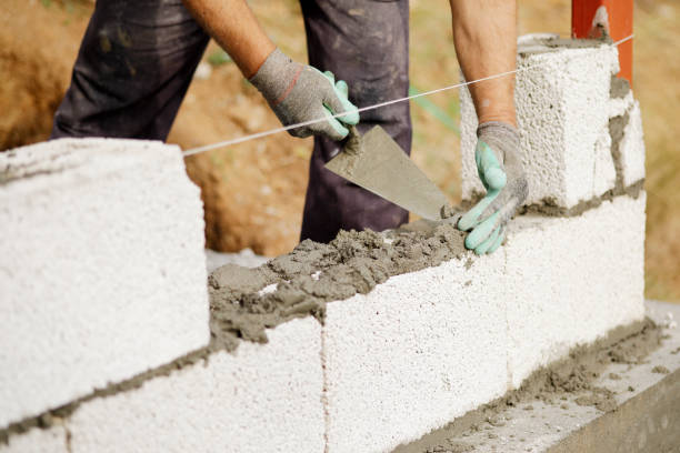 istock Close-up of construction worker builds brick wall 1207732396