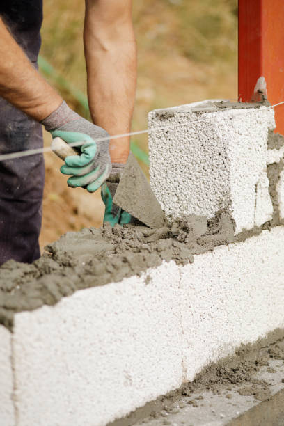 istock Close-up of construction worker builds brick wall 1207732665