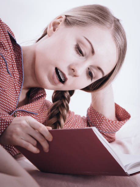 istock Woman relaxing in bed reading book 1207733820
