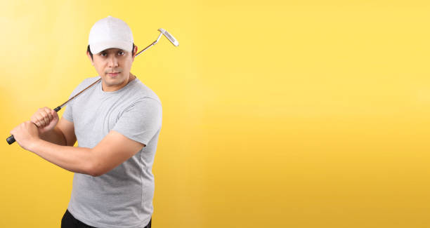 istock Golf Player Asian man in taking a swing, isolated on yellow background in studio With copy space. 1207735576