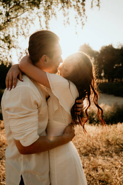 istock young couple walking on summer meadow at sunset 1207735639