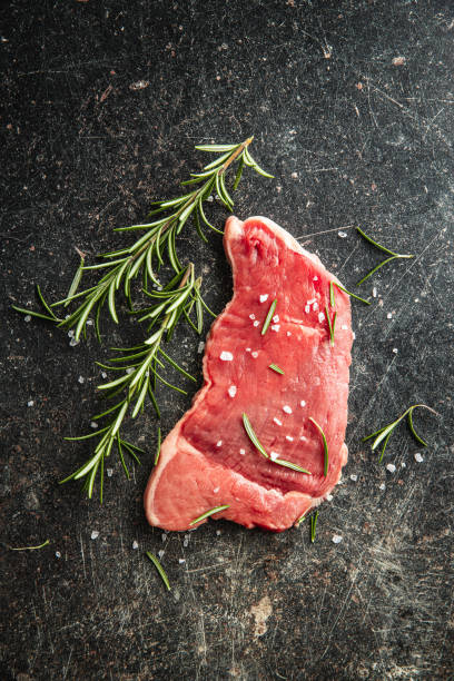 istock Raw veal schnitzel. Raw meat and rosemary 1207738775