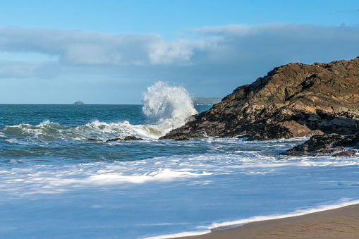 A large wave hitting the rugged coastline in Cornwall in January