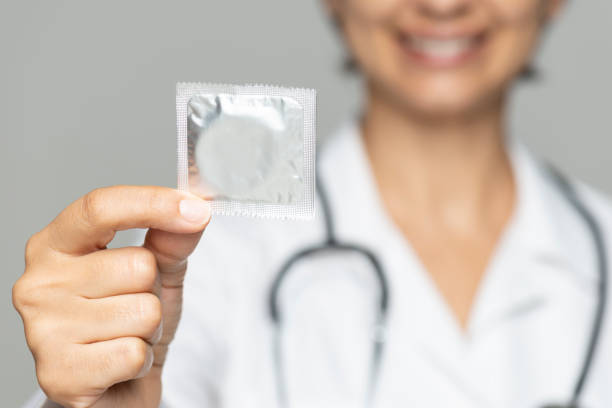 Use Condom Doctor holding and showing condom. condom photos stock pictures, royalty-free photos & images