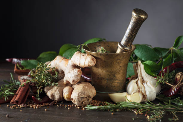 mortar with herbs and spices on a old wooden table. - mortar and pestle spice seasoning coriander seed imagens e fotografias de stock