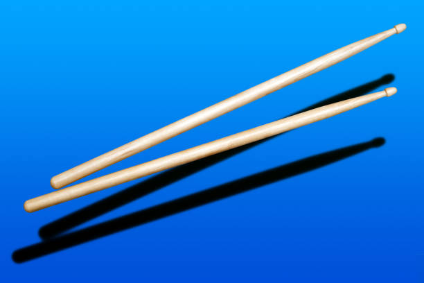 istock two wooden drumsticks on blue background 1207745444