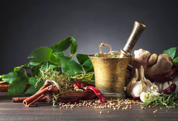 istock Mortar with herbs and spices on a old wooden table. 1207745456