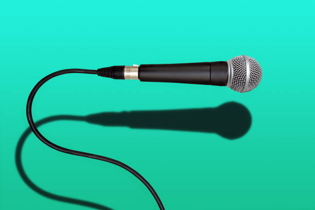 istock wired singer black and grey microphone on green color background 1207746231