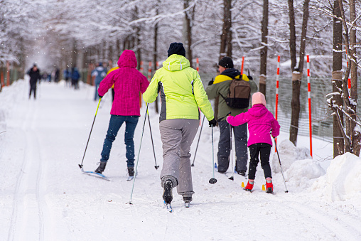 Family skiing at public Park Sokol'niki in Moscow during an amazing winter Day, Russia